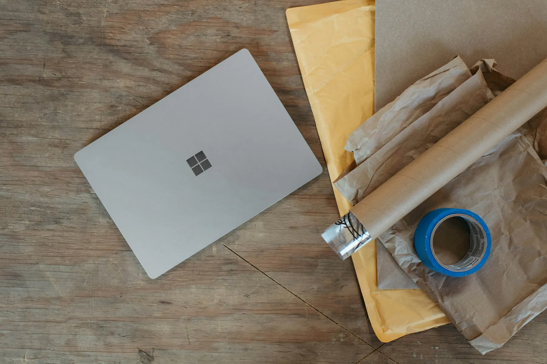 ノートPCと梱包資材が置かれた木製デスク